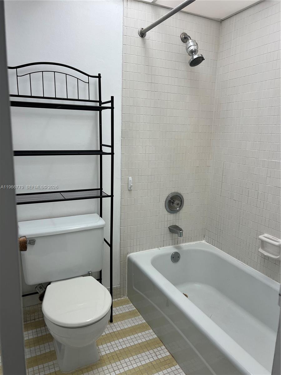 3690 Inverrary Drive, Unit 1K Lauderhill, FL 33319 - Photo 13 of 34 a bathroom with a toilet and a bathtub