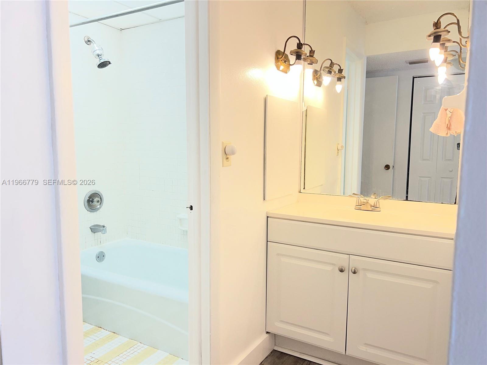 3690 Inverrary Drive, Unit 1K Lauderhill, FL 33319 - Photo 16 of 34 a bathroom with a shower sink and mirror