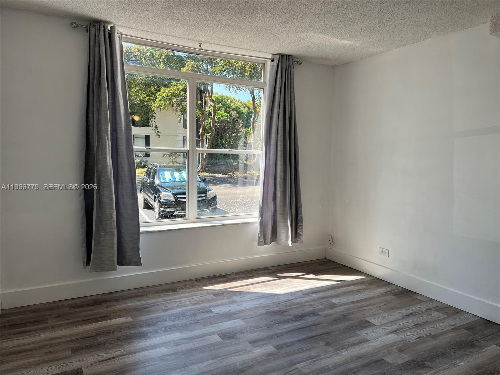 3690 Inverrary Drive, Unit 1K Lauderhill, FL 33319 - Photo 18 of 34 a view of a livingroom with wooden floor and a window