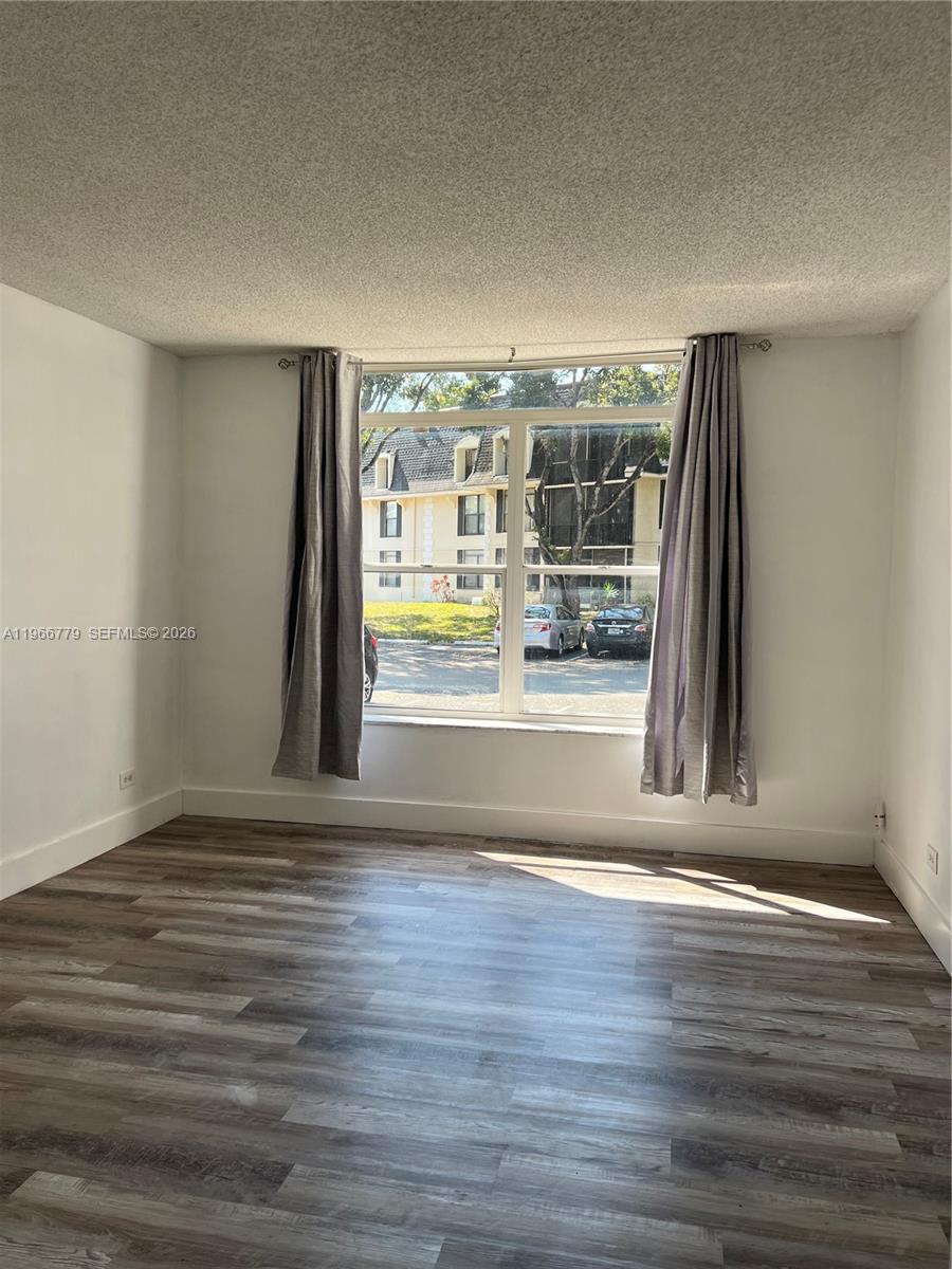 3690 Inverrary Drive, Unit 1K Lauderhill, FL 33319 - Photo 22 of 34 a view of an empty room with wooden floor and a window
