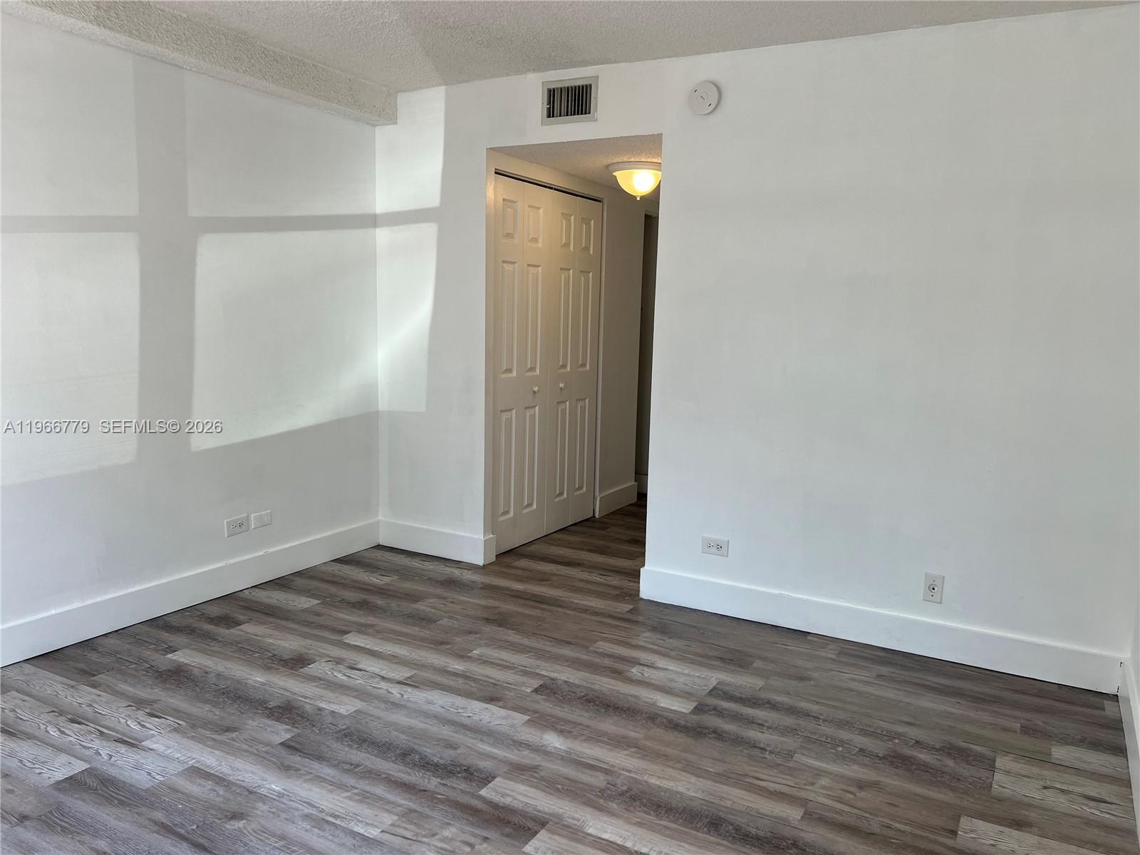 3690 Inverrary Drive, Unit 1K Lauderhill, FL 33319 - Photo 23 of 34 a view of an empty room with wooden floor