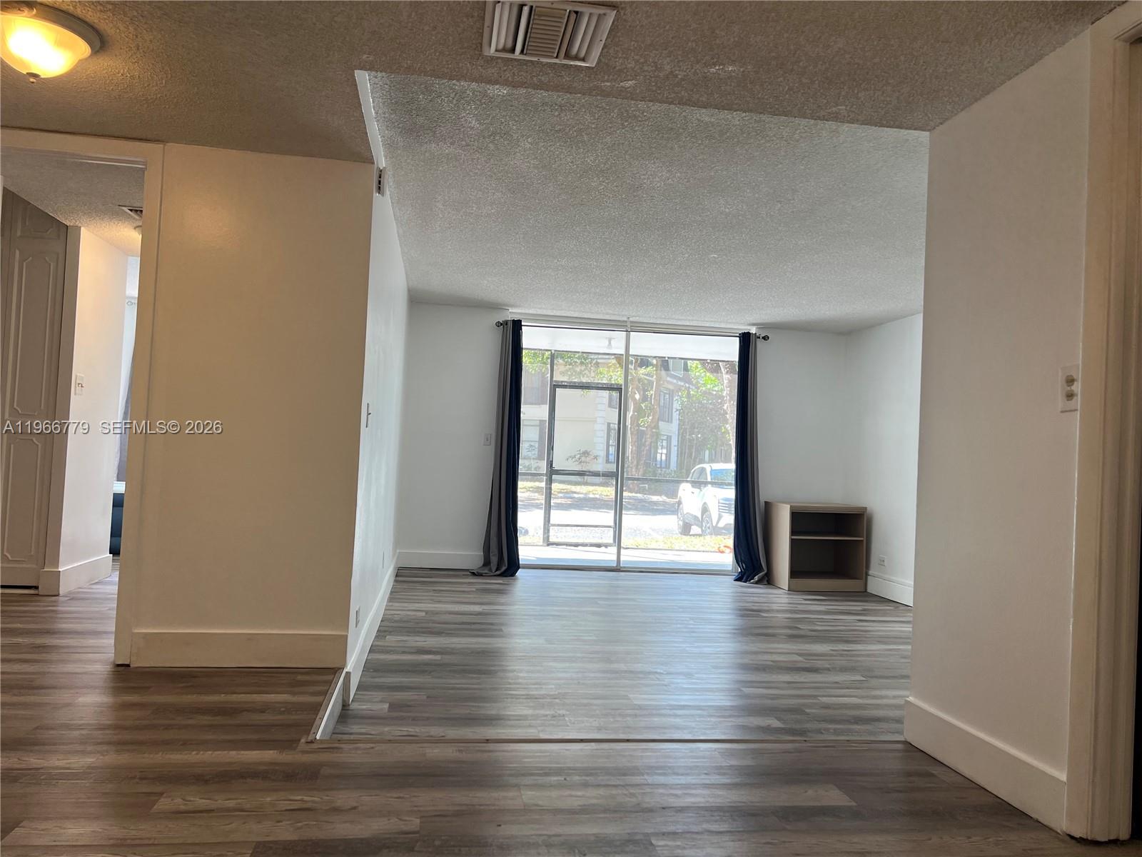 3690 Inverrary Drive, Unit 1K Lauderhill, FL 33319 - Photo 30 of 34 a view of an empty room with wooden floor and a window