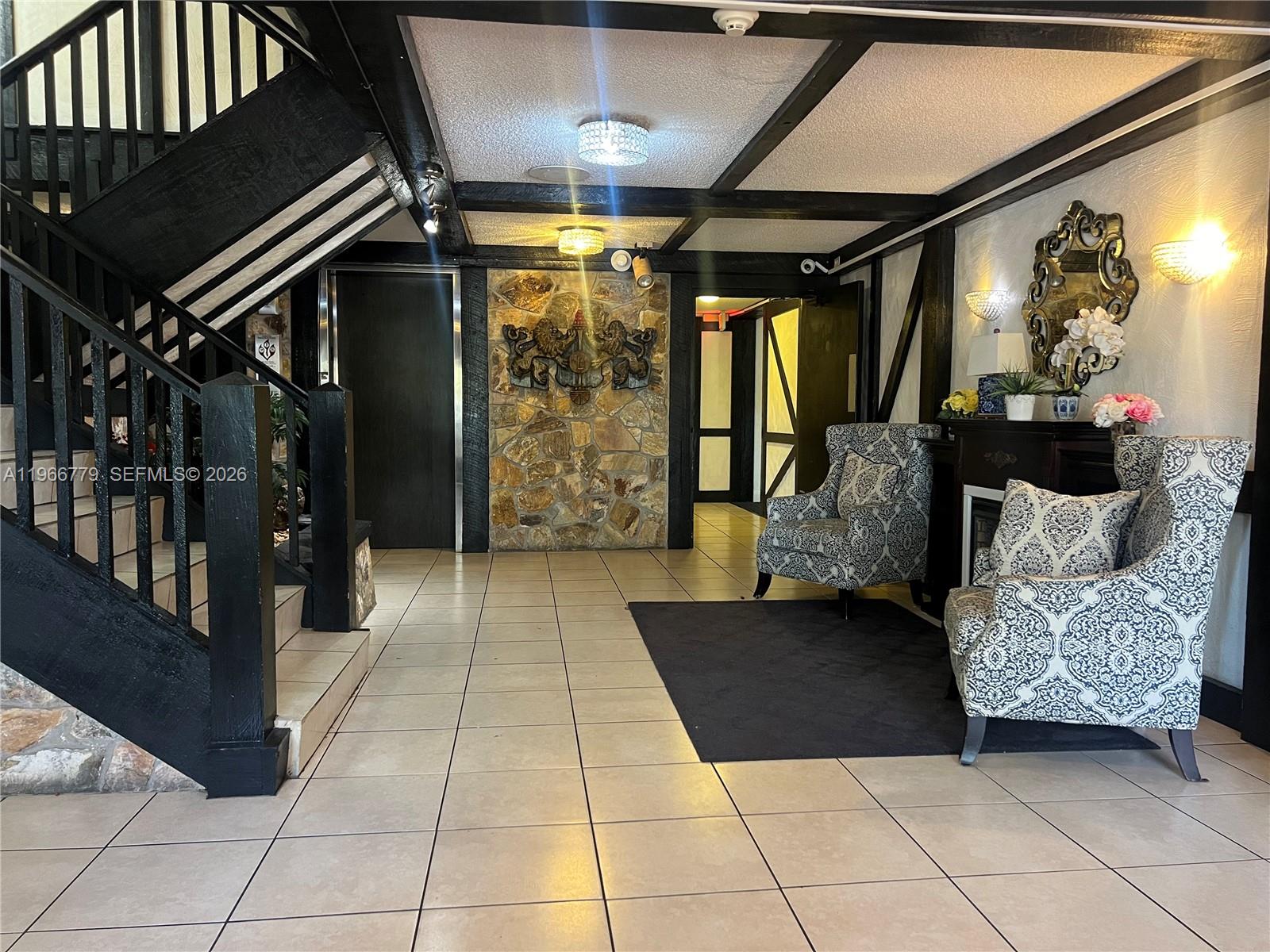 3690 Inverrary Drive, Unit 1K Lauderhill, FL 33319 - Photo 3 of 34 a hallway with furniture and a rug