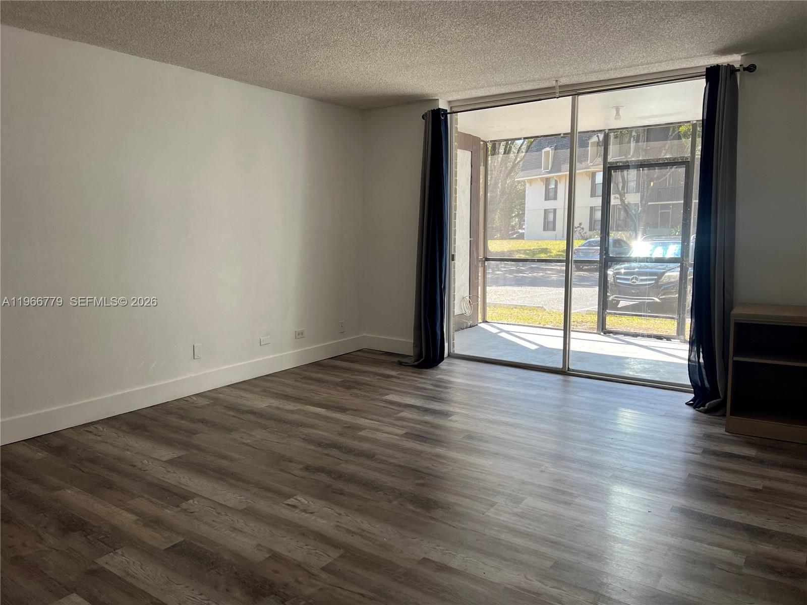 3690 Inverrary Drive, Unit 1K Lauderhill, FL 33319 - Photo 31 of 34 a view of an empty room with wooden floor and a window