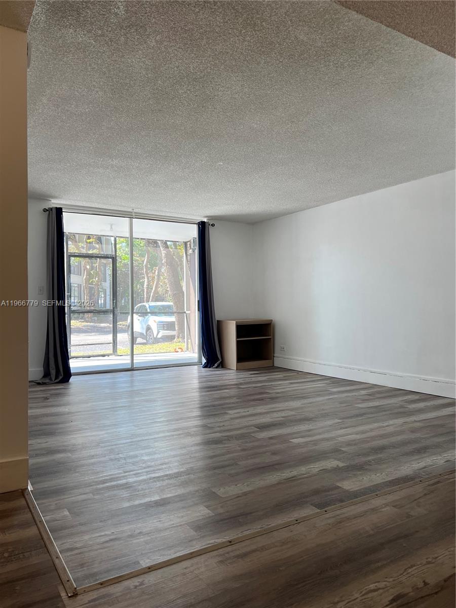 3690 Inverrary Drive, Unit 1K Lauderhill, FL 33319 - Photo 32 of 34 a view of empty room with wooden floor and floor to ceiling window