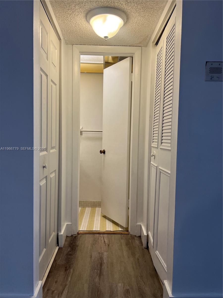3690 Inverrary Drive, Unit 1K Lauderhill, FL 33319 - Photo 6 of 34 a view of a hallway with wooden floor and closet