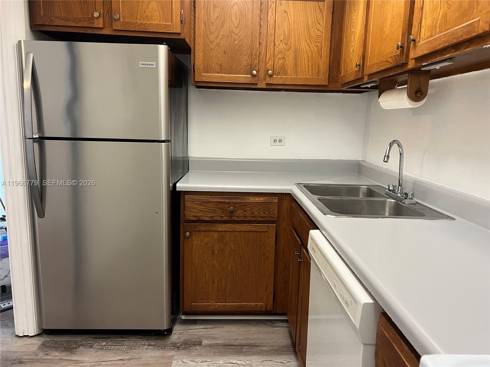 3690 Inverrary Drive, Unit 1K Lauderhill, FL 33319 - Photo 7 of 34 a kitchen with a refrigerator and a sink