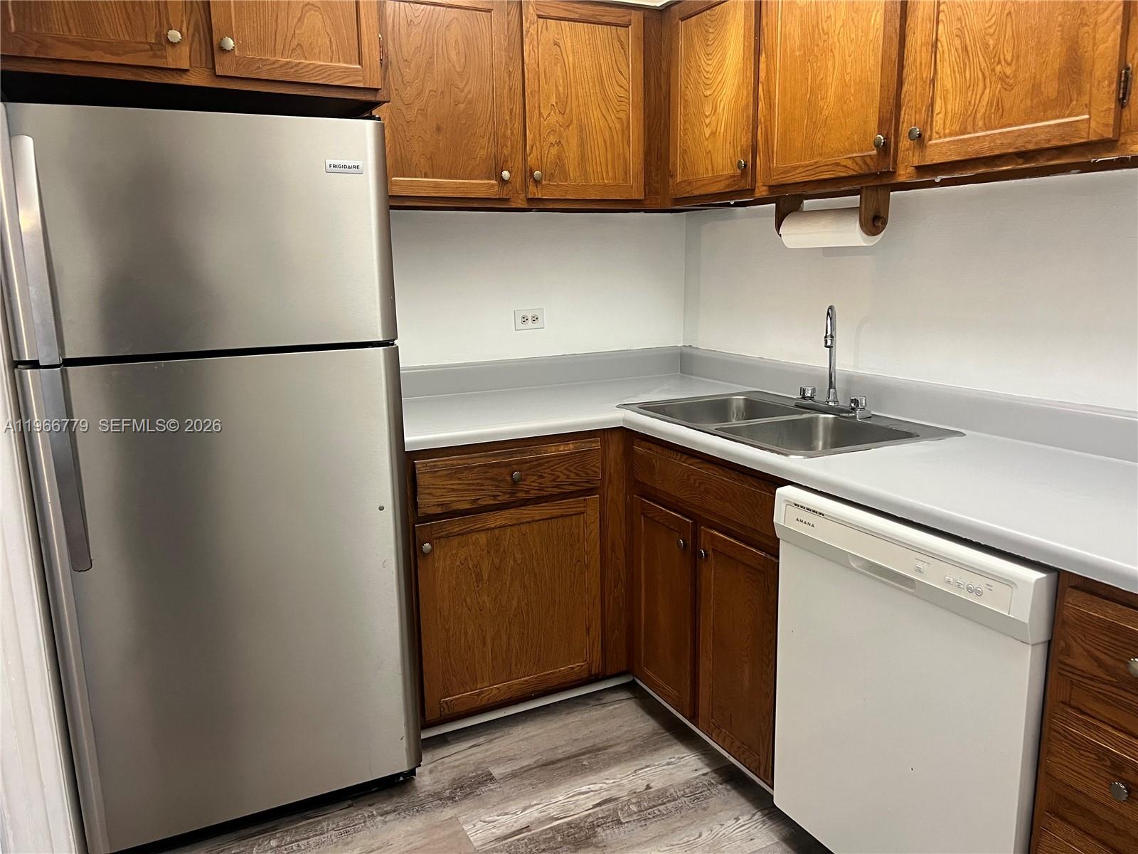 3690 Inverrary Drive, Unit 1K Lauderhill, FL 33319 - Photo 8 of 34 a kitchen with stainless steel appliances granite countertop a refrigerator a sink and dishwasher
