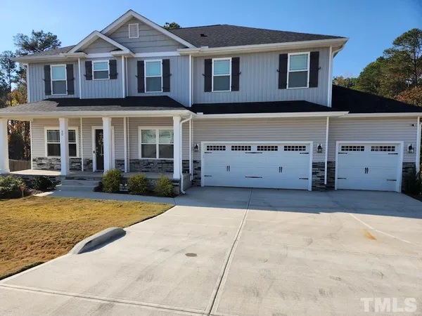 a view of a white house with a yard and large tree