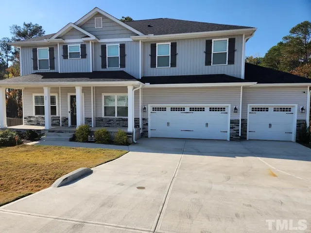 a view of a white house with a yard and large tree