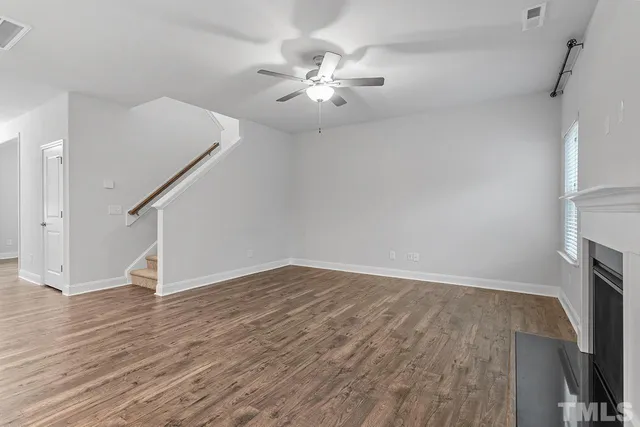 a view of a livingroom with wooden floor and a ceiling fan