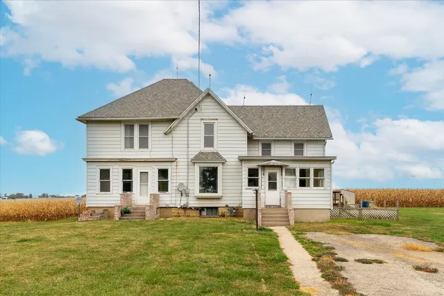 a white house that has a big yard and more windows