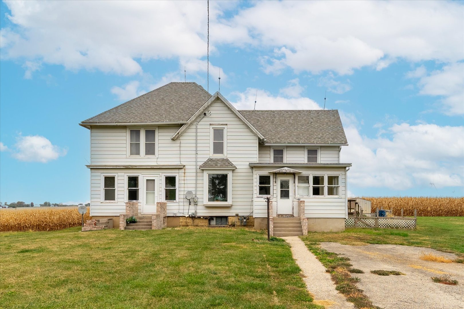 a white house that has a big yard and more windows