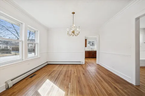 a view of empty room with wooden floor and window