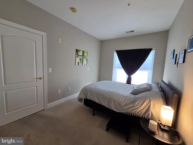 a bedroom with a bed and a painting on the wall