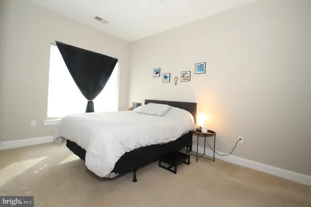 a spacious bedroom with a bed and a flat screen tv