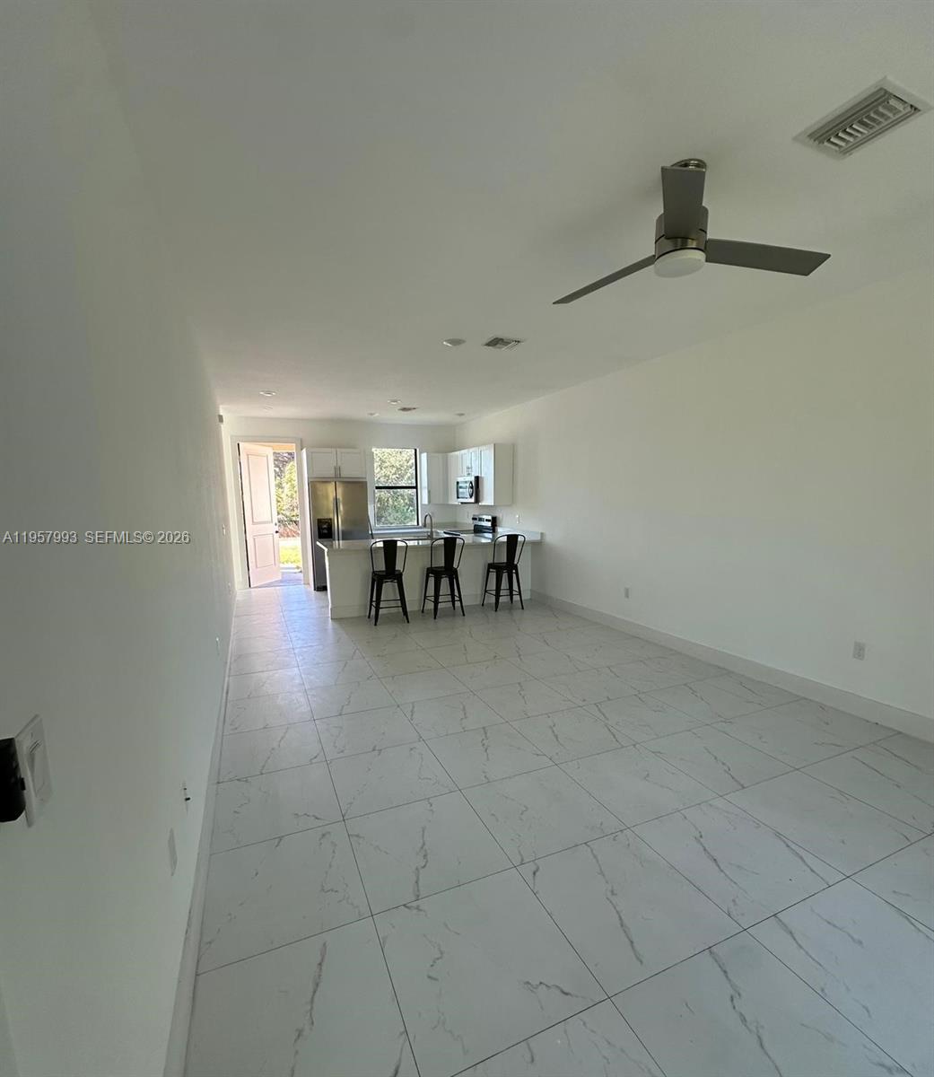 4660-4662 26th Street Southwest Lehigh Acres, FL 33973 - Photo 10 of 22 a dining room with furniture and a chandelier fan