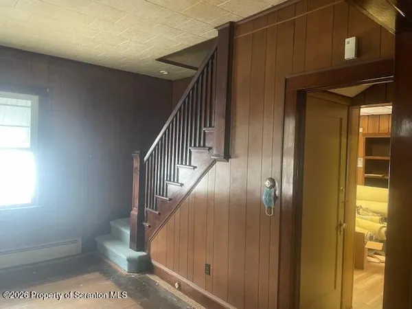 a view of entryway and hall with wooden floor