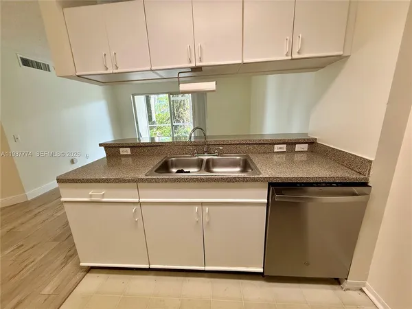 a utility room with granite countertop cabinets washer and dryer