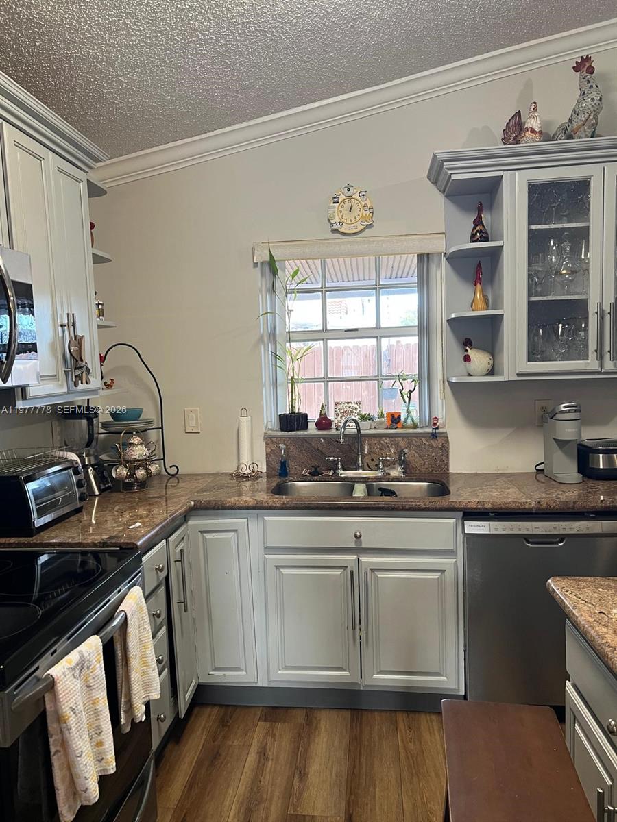 4911 Southwest 142nd Place Miami, FL 33175 - Photo 15 of 34 a kitchen with stainless steel appliances a sink stove and cabinets