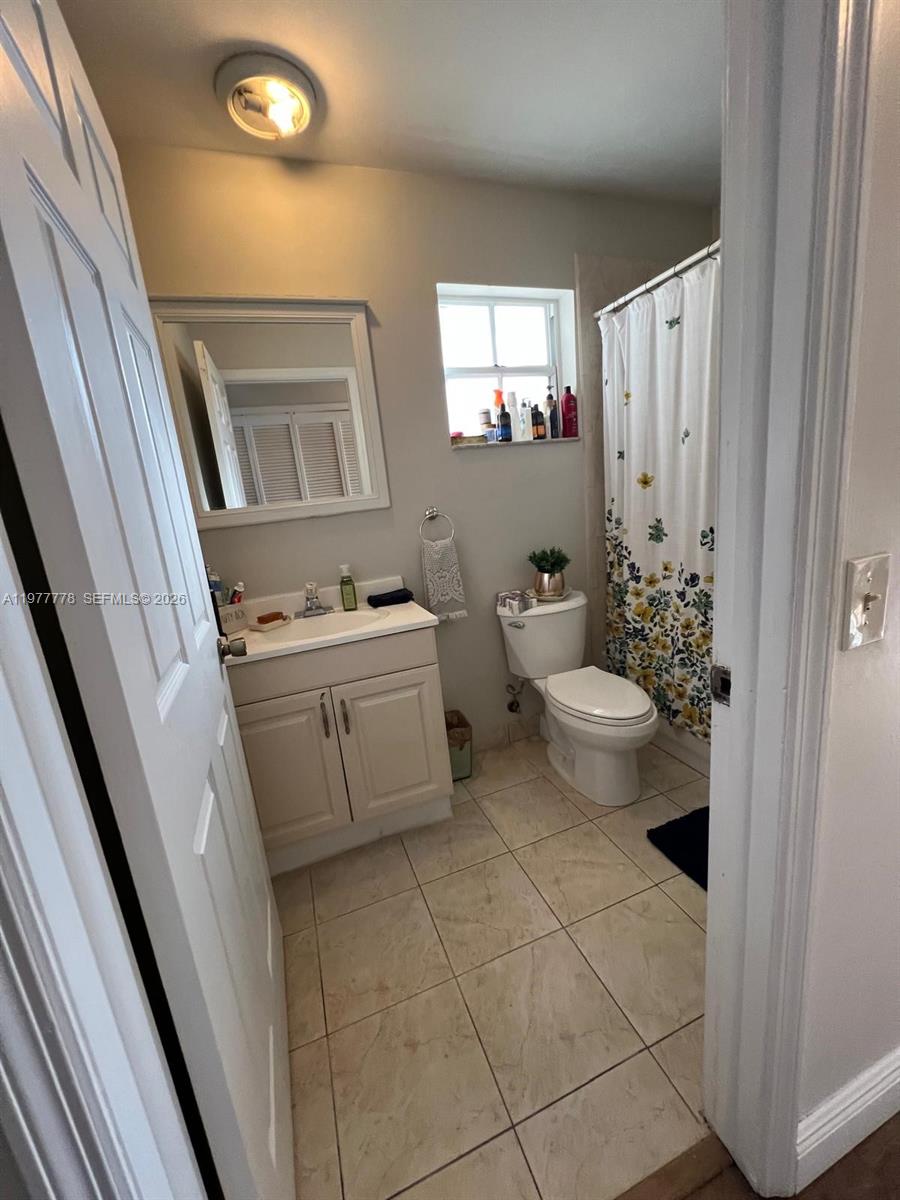 4911 Southwest 142nd Place Miami, FL 33175 - Photo 24 of 34 a bathroom with a sink a toilet and a mirror