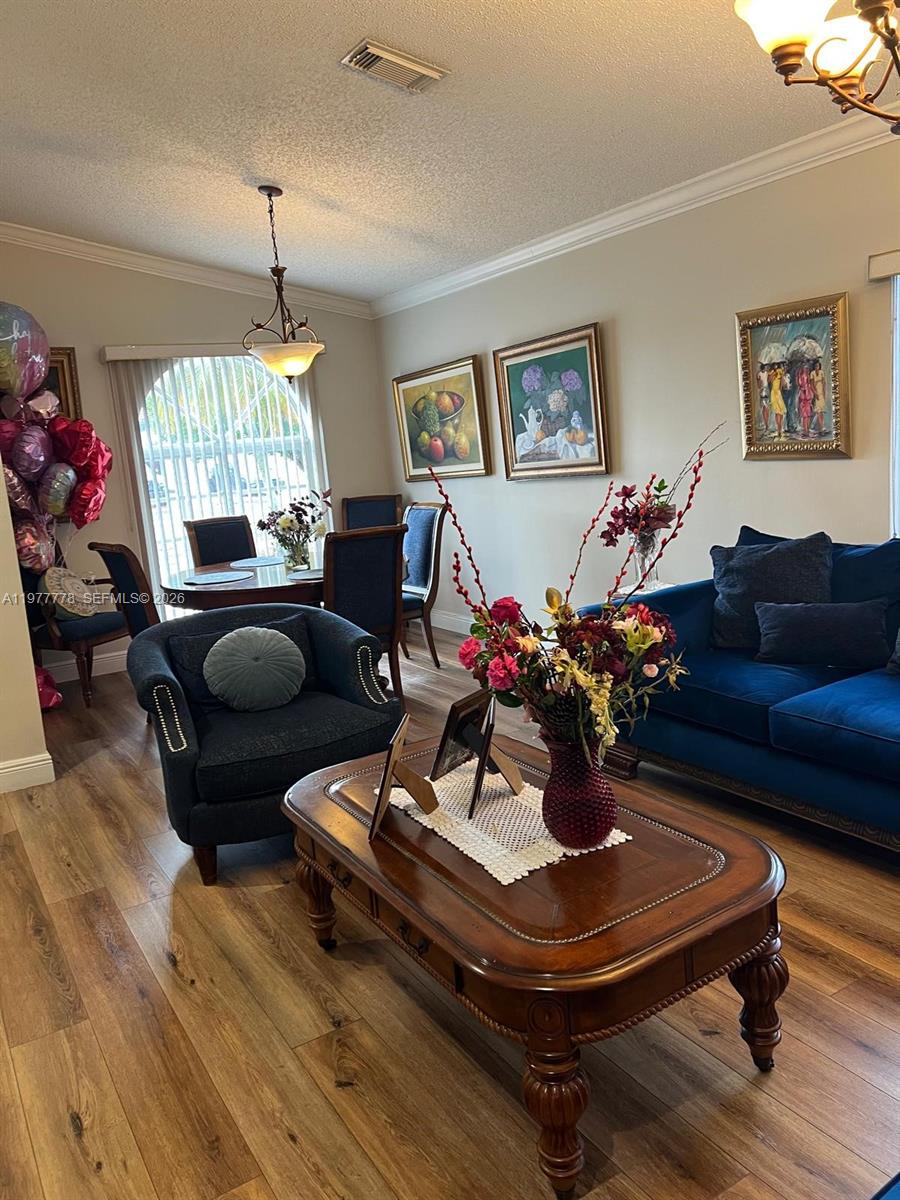 4911 Southwest 142nd Place Miami, FL 33175 - Photo 7 of 34 a living room with furniture a window and a chandelier