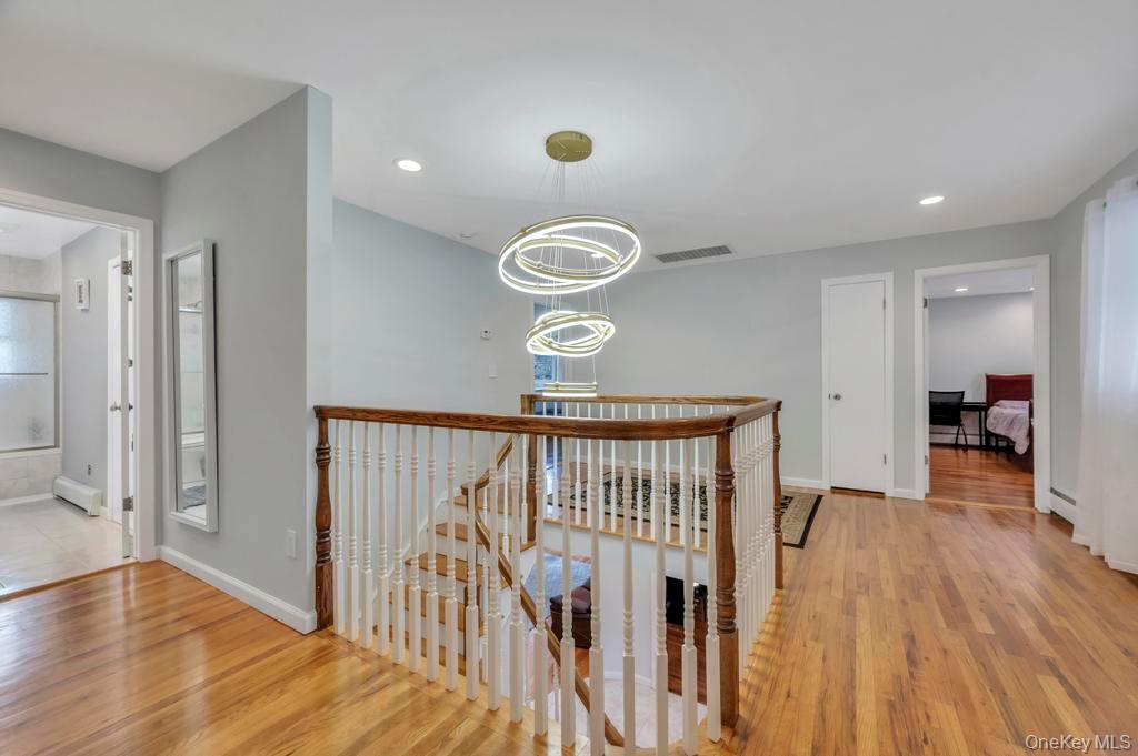 10 Hunting Hill Road Woodbury, NY 11797 - Photo 19 of 39 a view of a hallway with wooden floor and staircase