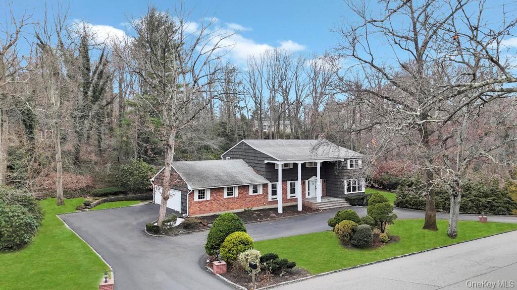 10 Hunting Hill Road Woodbury, NY 11797 - Photo 2 of 39 a front view of a house with garden