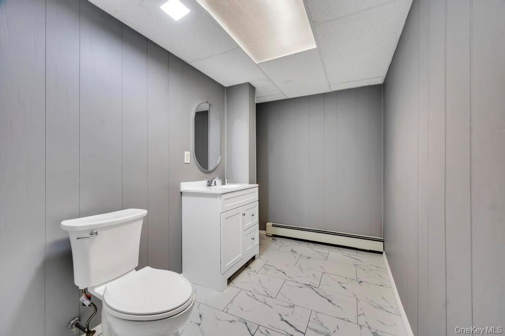 10 Hunting Hill Road Woodbury, NY 11797 - Photo 25 of 39 a white toilet sitting next to a bathroom sink