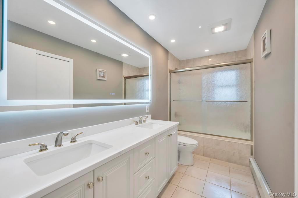 10 Hunting Hill Road Woodbury, NY 11797 - Photo 26 of 39 a bathroom with a double vanity sink mirror and toilet