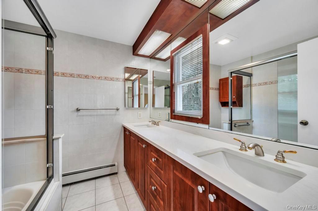 10 Hunting Hill Road Woodbury, NY 11797 - Photo 27 of 39 a spacious bathroom with a double vanity sink and a mirror