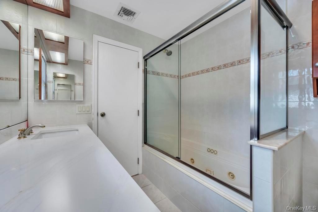 10 Hunting Hill Road Woodbury, NY 11797 - Photo 28 of 39 a bathroom with a bathtub and a shower