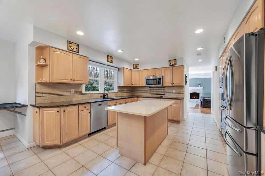 10 Hunting Hill Road Woodbury, NY 11797 - Photo 3 of 39 a kitchen with stainless steel appliances granite countertop a refrigerator sink and cabinets