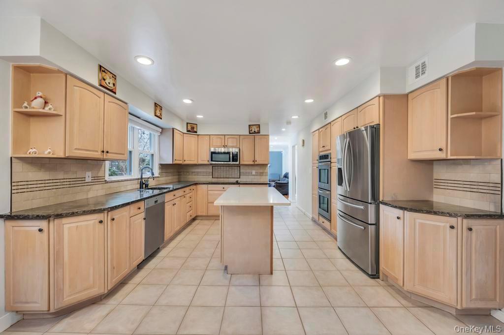 10 Hunting Hill Road Woodbury, NY 11797 - Photo 4 of 39 a kitchen with stainless steel appliances granite countertop a refrigerator and a sink