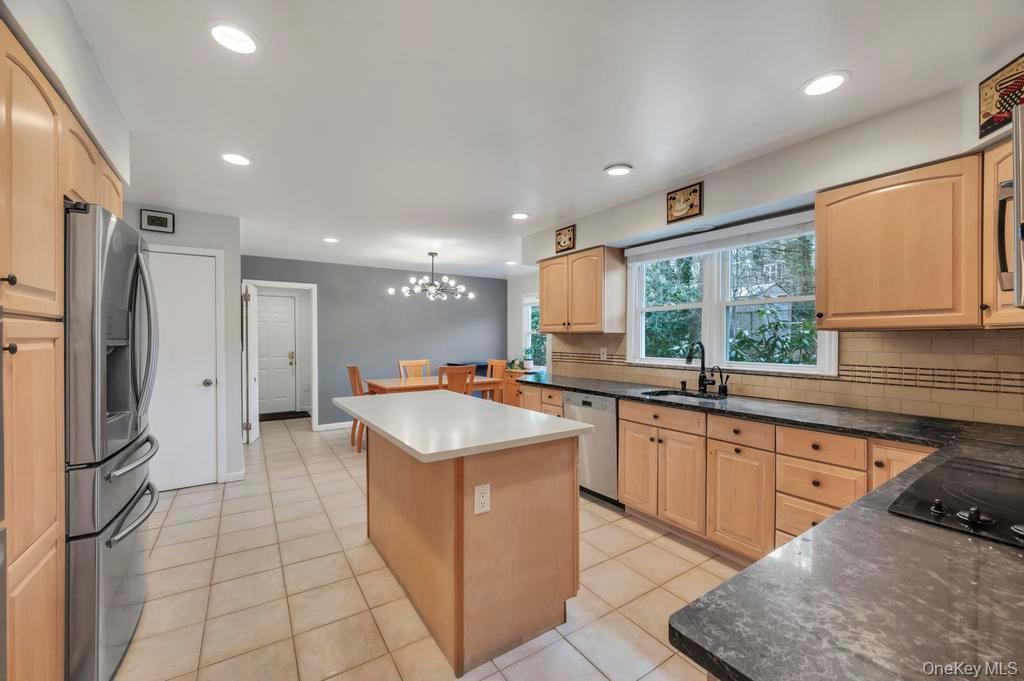 10 Hunting Hill Road Woodbury, NY 11797 - Photo 5 of 39 a kitchen with stainless steel appliances granite countertop a sink and a refrigerator