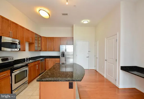 a kitchen with stainless steel appliances a sink stove and cabinets