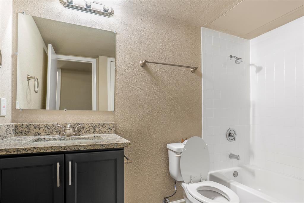 8110 Skillman Street, Unit 1027 Dallas, TX 75231 - Photo 1 of 19 a bathroom with a granite countertop sink toilet and shower
