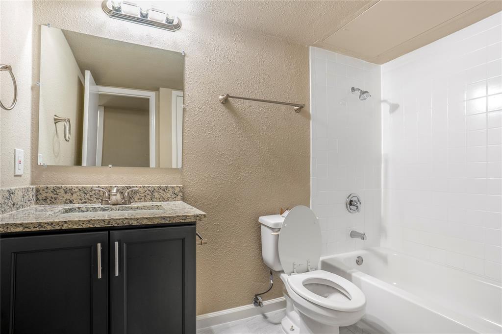 8110 Skillman Street, Unit 1027 Dallas, TX 75231 - Photo 12 of 19 a bathroom with a granite countertop toilet sink and mirror