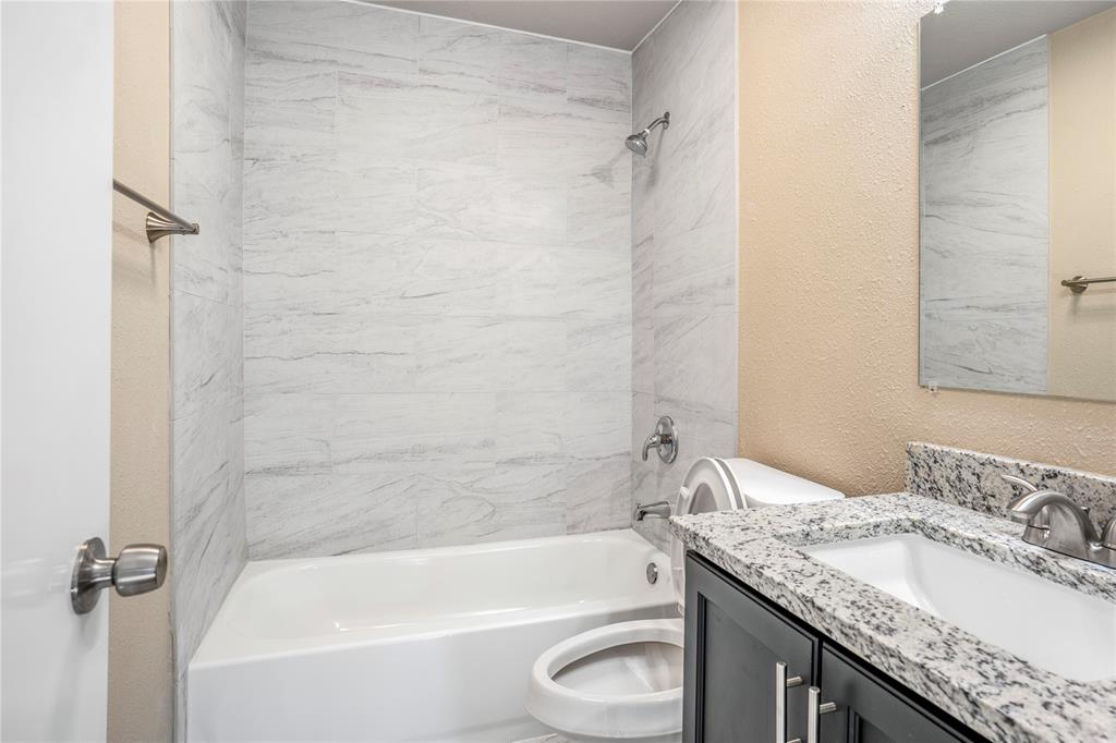 8110 Skillman Street, Unit 1027 Dallas, TX 75231 - Photo 13 of 19 a bathroom with a granite countertop bathtub sink vanity mirror and toilet