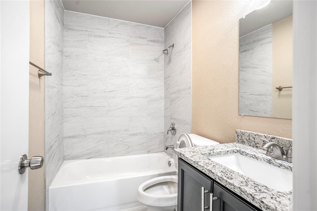 8110 Skillman Street, Unit 1027 Dallas, TX 75231 - Photo 4 of 19 a bathroom with a granite countertop bathtub shower sink vanity and toilet