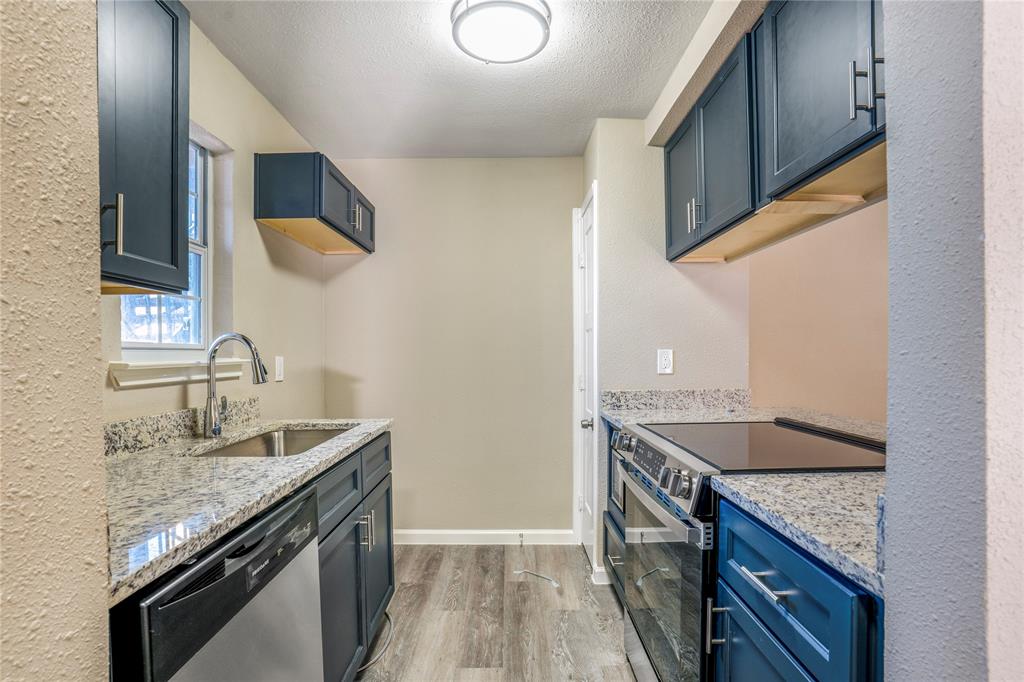 8110 Skillman Street, Unit 1027 Dallas, TX 75231 - Photo 6 of 19 a kitchen with granite countertop a sink and a stove