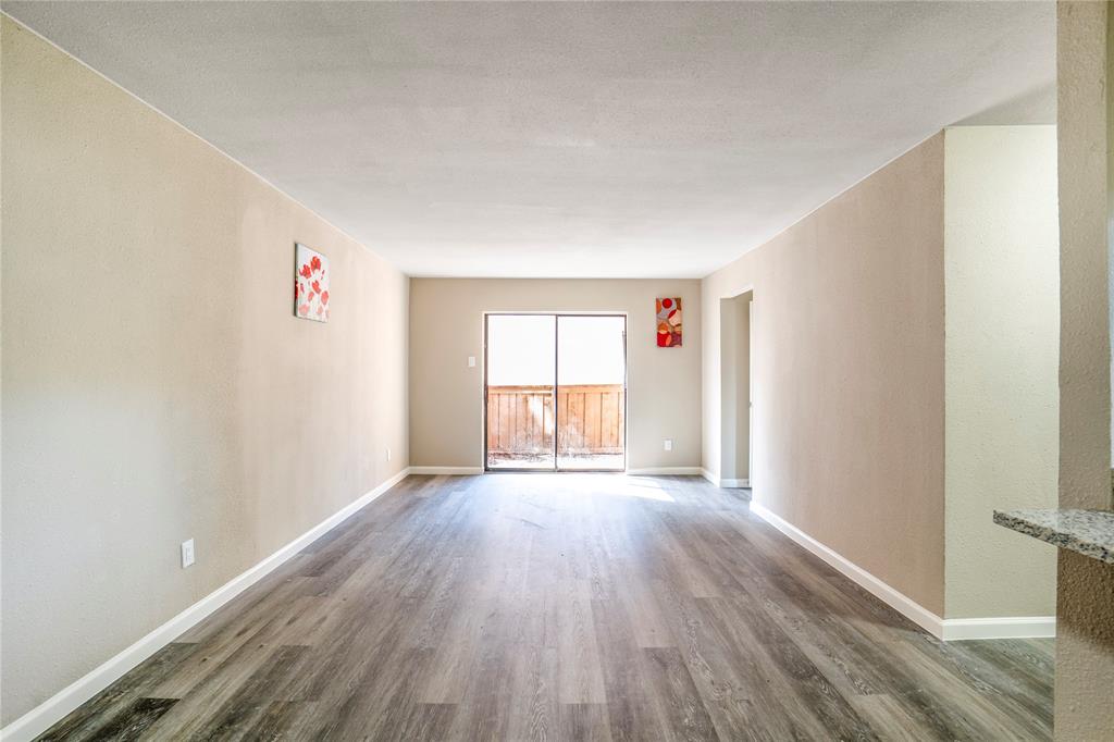 8110 Skillman Street, Unit 1027 Dallas, TX 75231 - Photo 8 of 19 a view of an empty room with wooden floor and a window