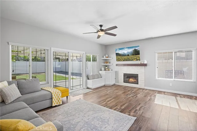 a living room with furniture a fireplace and a floor to ceiling window