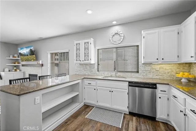 a kitchen with granite countertop stainless steel appliances sink cabinets and window