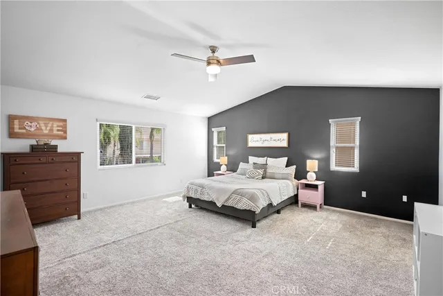 a spacious bedroom with a bed and a dresser