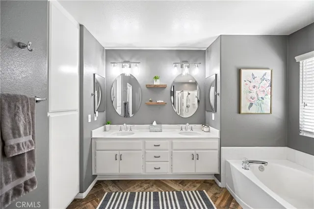a spacious bathroom with a double vanity sink a mirror and a bathtub