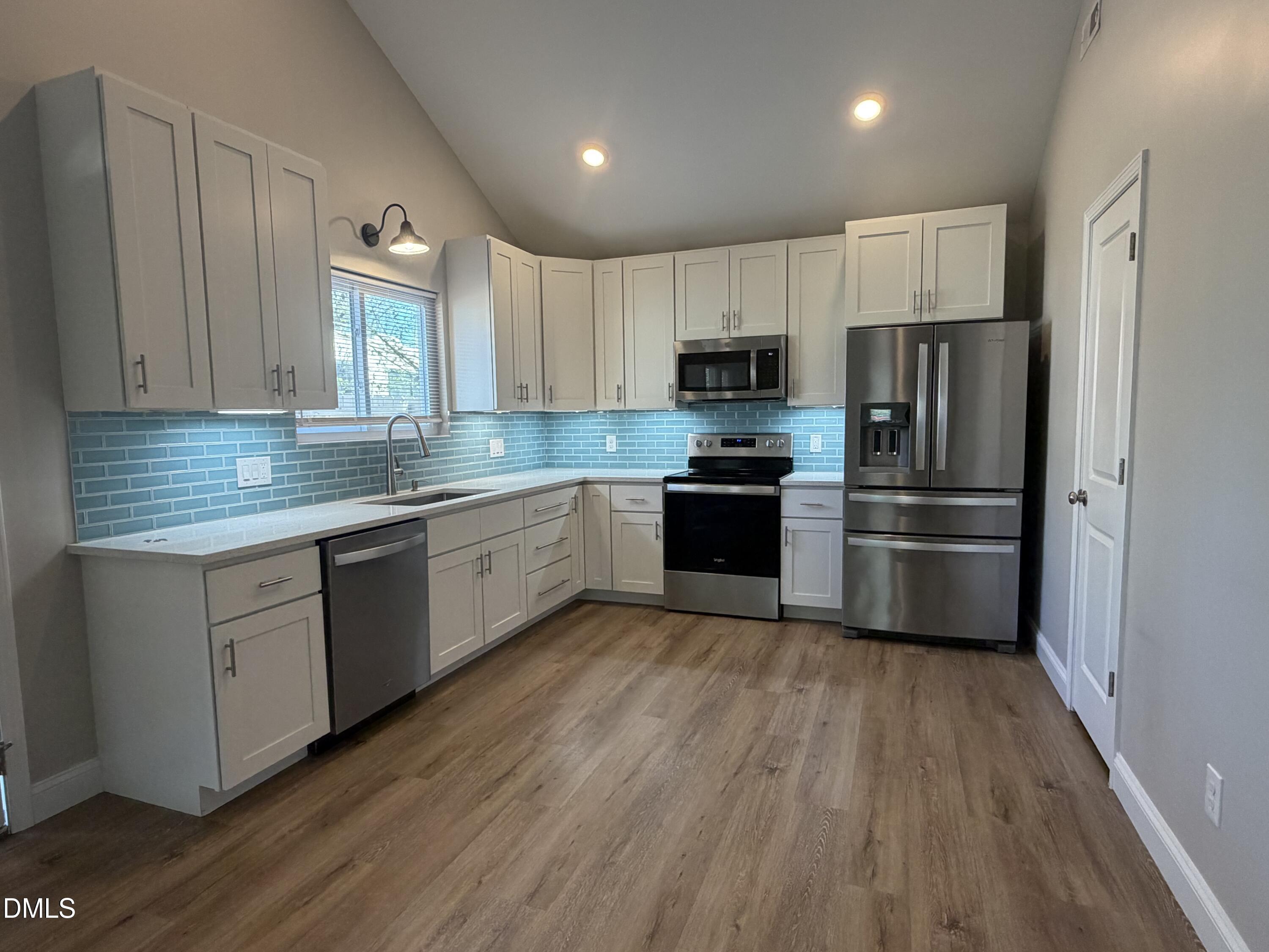 507 North Maple Street, Unit A Durham, NC 27703 - Photo 3 of 15 a kitchen with stainless steel appliances a refrigerator sink and cabinets