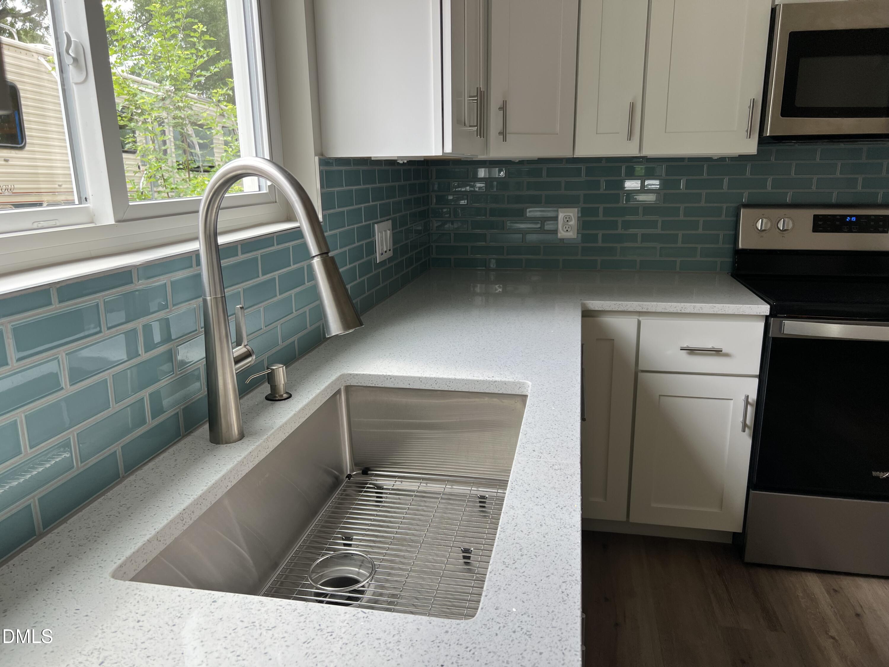 507 North Maple Street, Unit A Durham, NC 27703 - Photo 6 of 15 a kitchen with granite countertop a sink a stove and cabinets