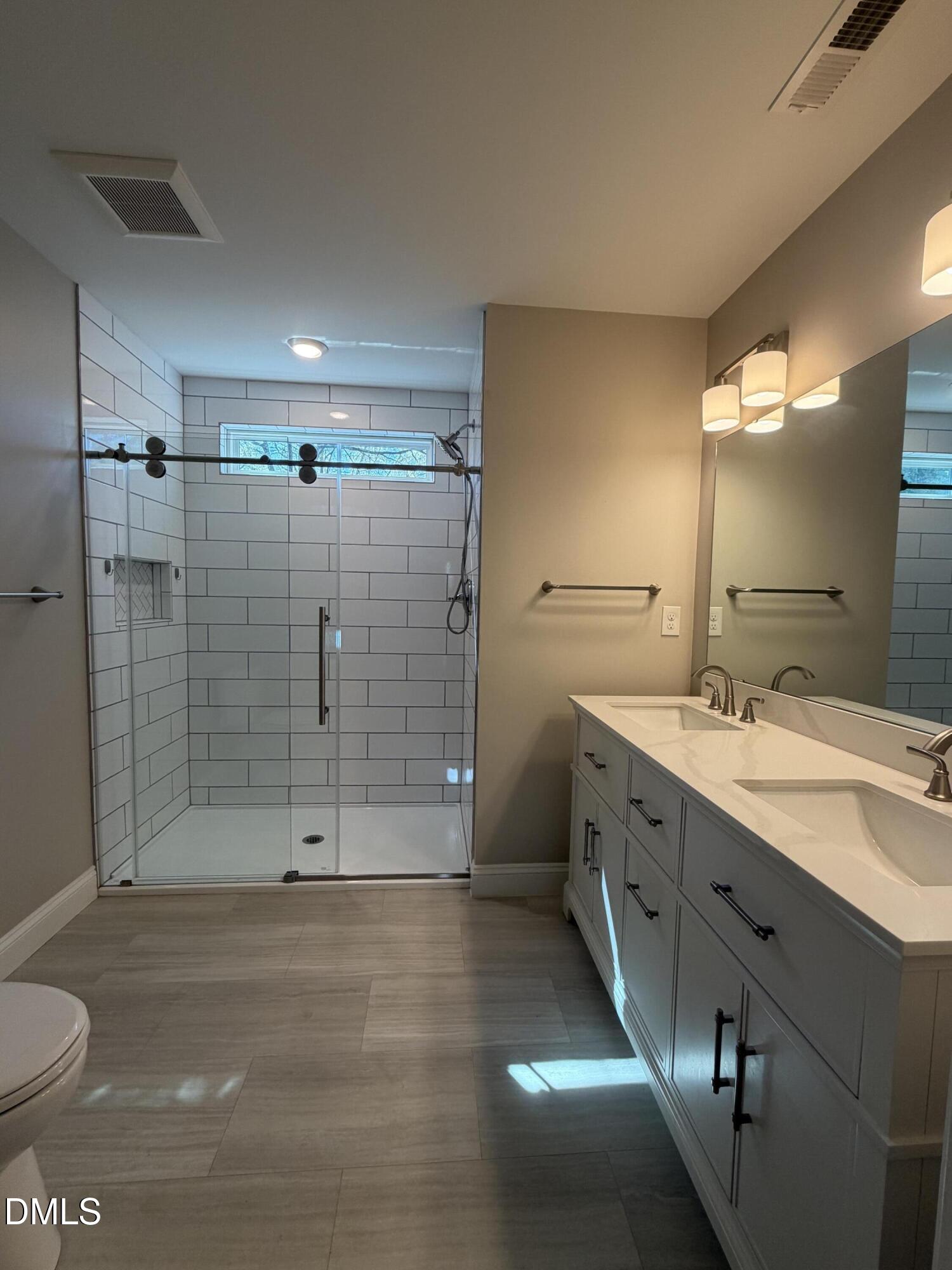 507 North Maple Street, Unit A Durham, NC 27703 - Photo 9 of 15 a bathroom with a shower sink and mirror