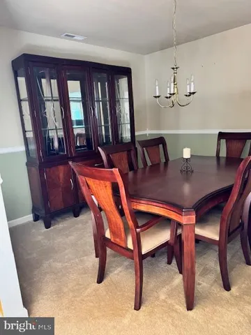 a view of a dining room with furniture and chandelier